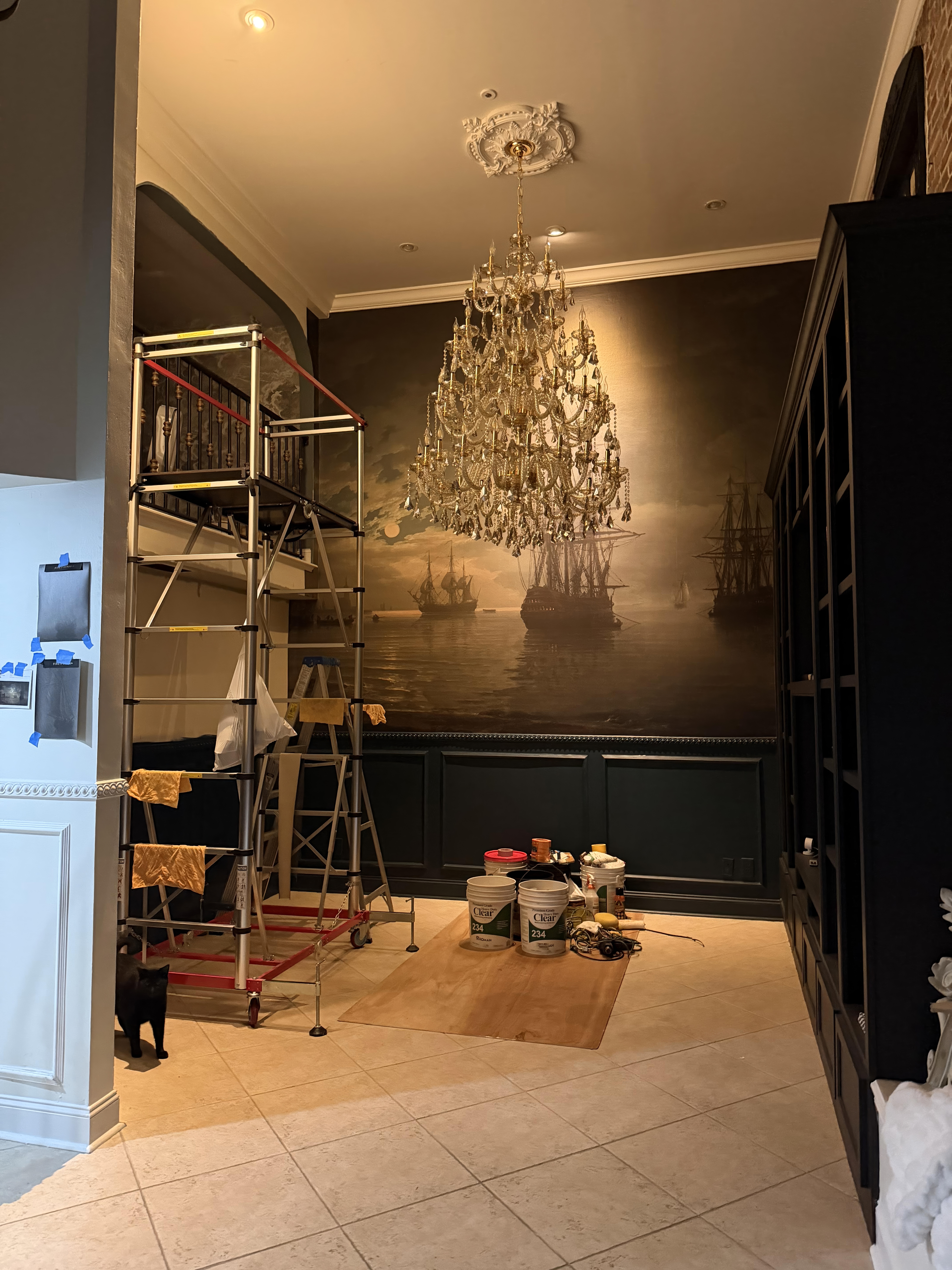 Tools and materials staged mid-installation beneath a crystal chandelier