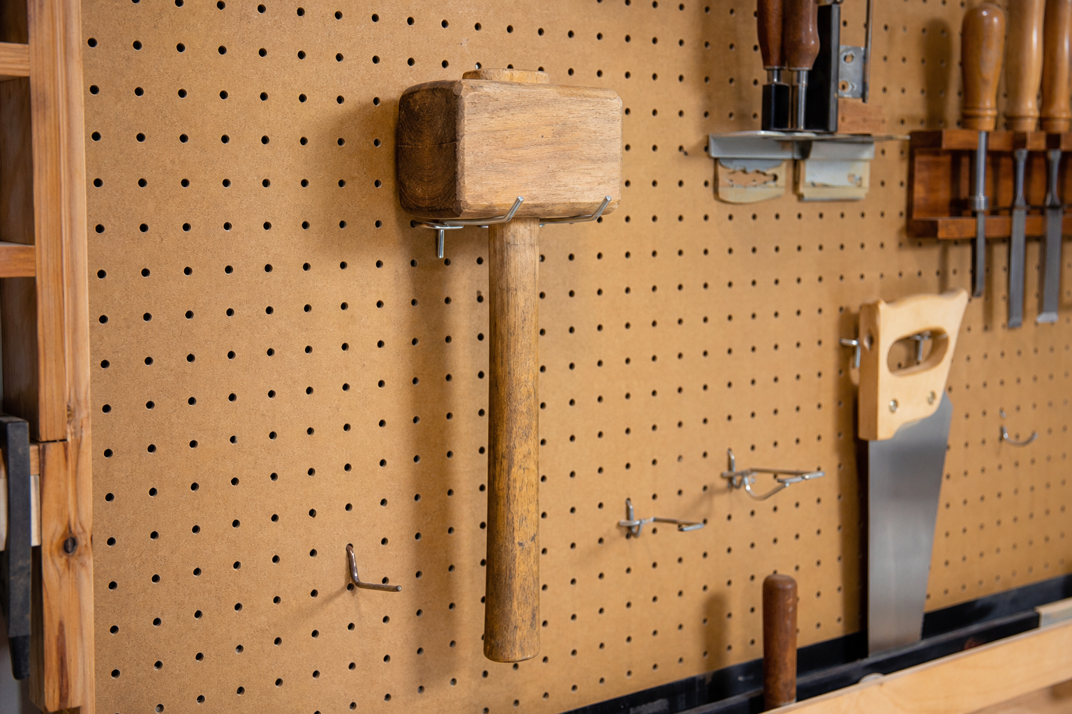 Wooden mallet hanging on a pegboard tool wall