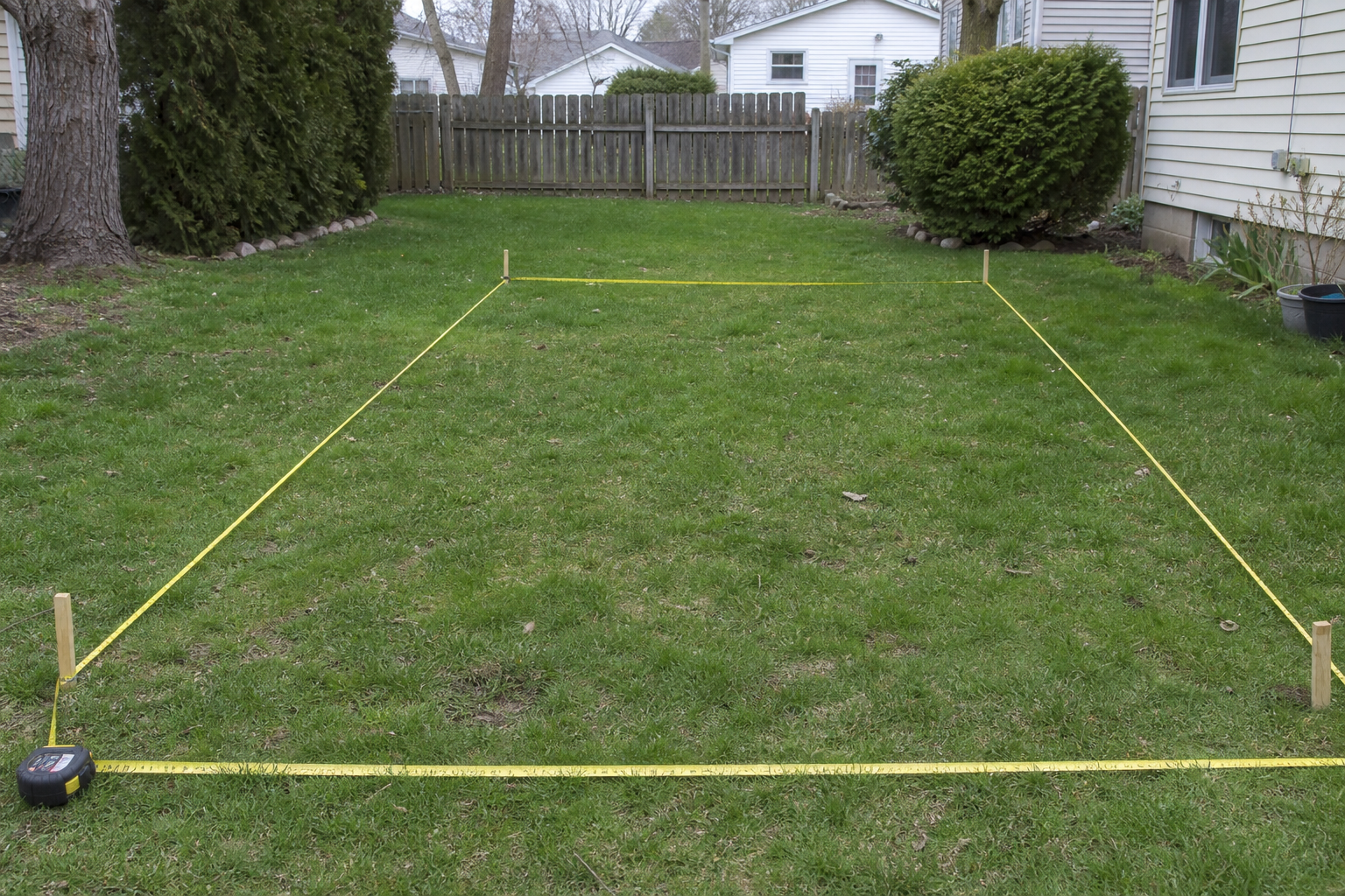Best Shed Size for Suburban Lots: Complete Comparison Guide 2 Tape measure stretched across a suburban backyard plot