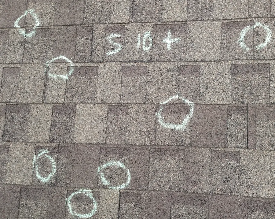 Multiple hail impacts circled with size measurements on test square